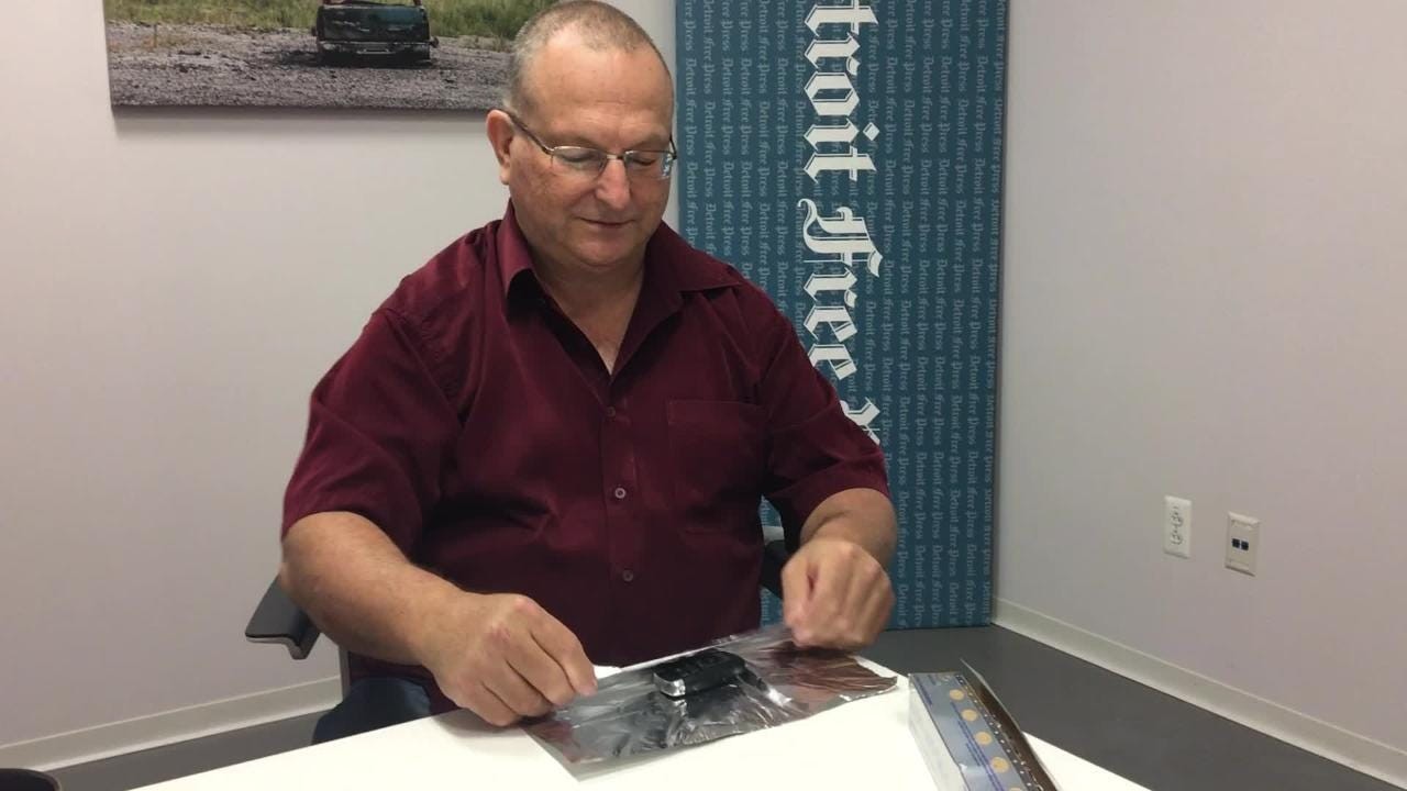 Man holding a metal coffee can, demonstrating how to store a key fob to block signals.