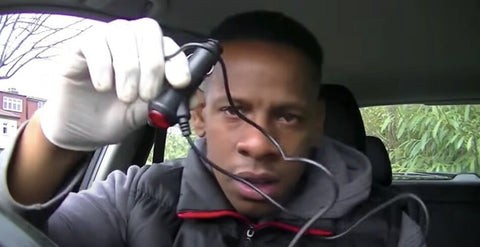 Mechanic inspecting car wiring for a hidden tracker