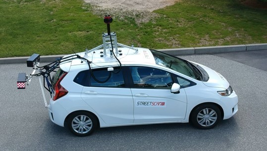 Street scan car equipped with advanced sensors assessing road conditions in Carmel, Indiana.