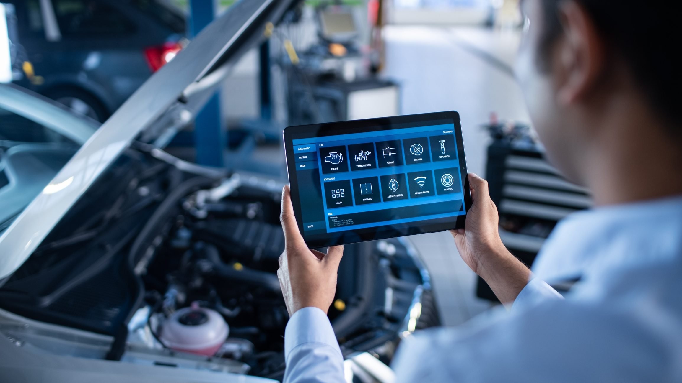 Car Service Manager or Mechanic Uses a Tablet Computer with a Futuristic Interactive Diagnostics Software. Specialist Inspecting the Vehicle in Order to Find Broken Components In the Engine Bay.